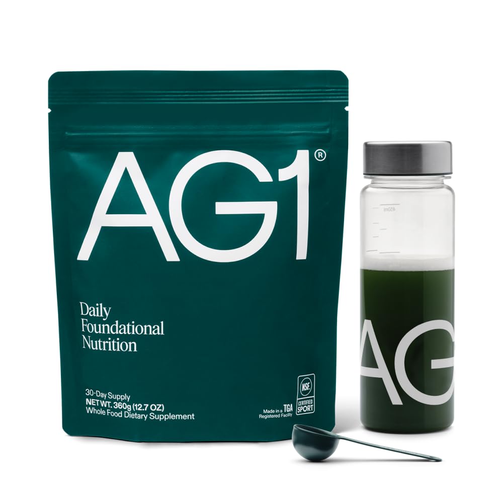 AG1 greens powder bottle with scoop on counter for daily nutrition and gut support.