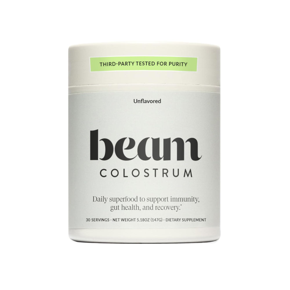 Beam Colostrum Powder bottle with scoop highlights immune support and gut health.