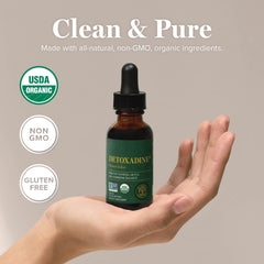 Hand holding Detoxadine bottle for convenient thyroid-friendly wellness routine