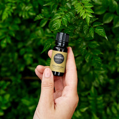 Edens Garden Chamomile Roman oil bottle beside a diffuser for soothing scents.