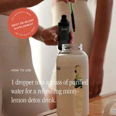 Glass of water with Juna Drops ready for hydration.