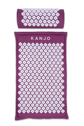 Kanjo acupressure mat in amethyst on bed, targeting back pressure points for relaxed muscles.