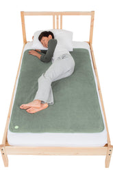 PeapodMats bedwetting mat in sage flat lay showing secure protection