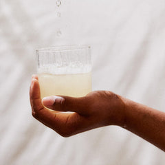 Stirring Perelel Hydration Support into water for a citrus sip.