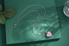 QINJIEJIE Rose Quartz Heart pendant in hand, portable energy for calm.