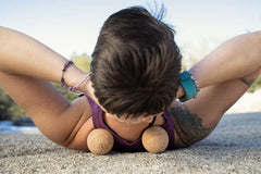Rawlogy cork massage ball held in hand for precise self-massage on tight spots.