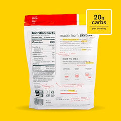 Skratch Labs Strawberry Lemonade scoop dispensing into a glass for rehydration