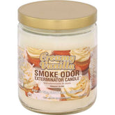 Smoke Odor Exterminator Creamy Vanilla 13oz candle on a table, inviting fragrance to freshen a room.