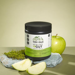 Scoop pours Terra Origin Healthy Gut Green Apple powder into a glass.
