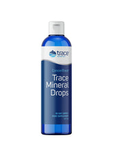 Trace Minerals Concentrace mineral drops bottle beside a glass of water for daily mineral support.
