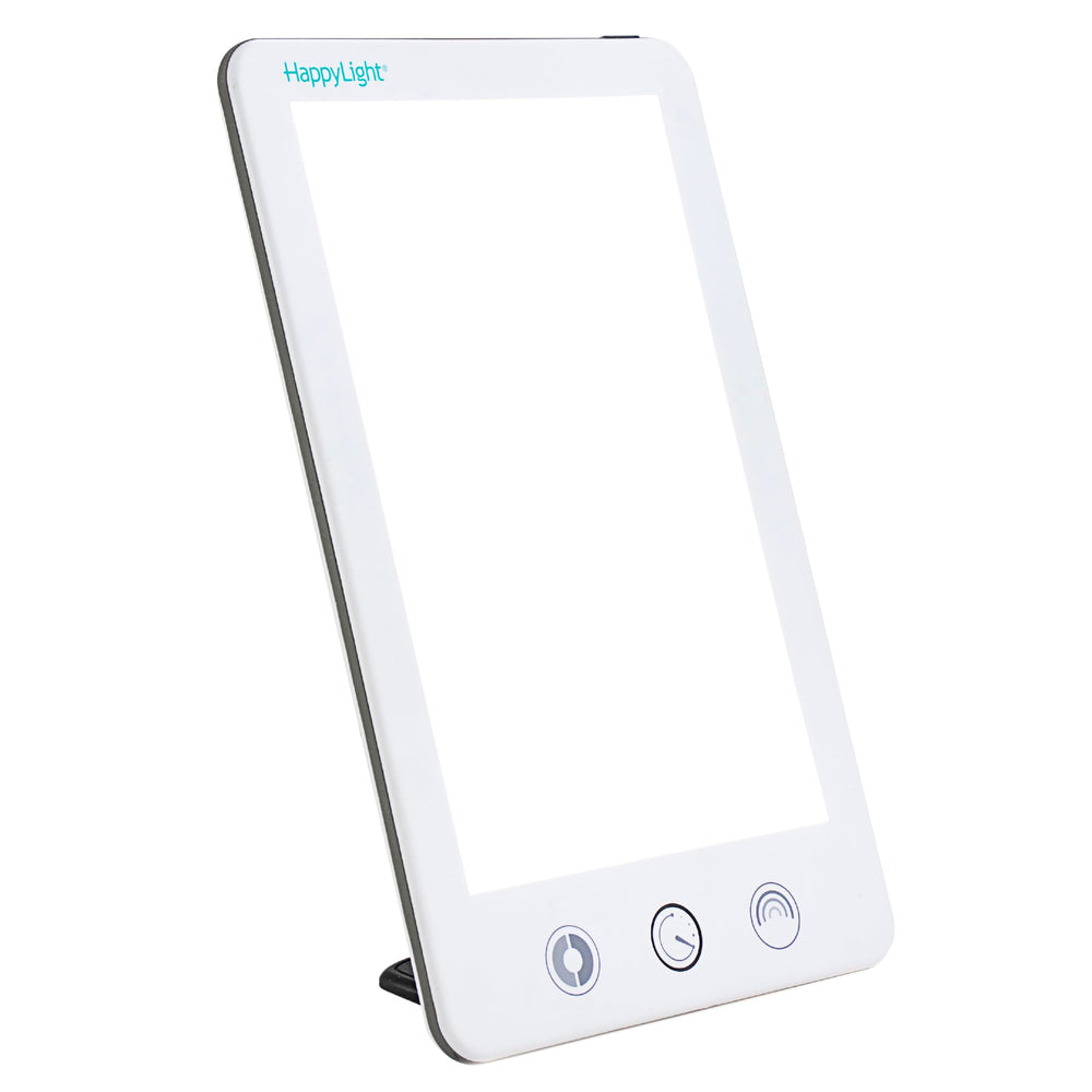 Verilux HappyLight Touch Plus on a desk delivering 10,000 lux for daytime energy.
