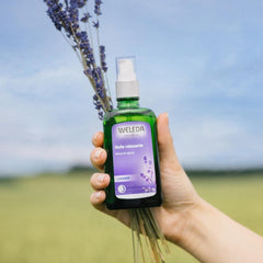 Hands applying Weleda lavender oil for a relaxing massage.