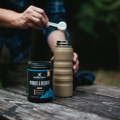 Wilderness Athlete mixed hydration drink in glass with blue raspberry flavor.