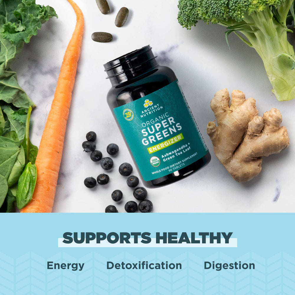 Ancient Nutrition Supergreens Energizer bottle with glass of water on table