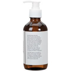 Arnica Oil being poured into hands for massage preparation.