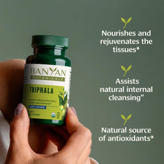 Banyan Botanicals Triphala Tablets close-up label shows organic, non-GMO assurance.