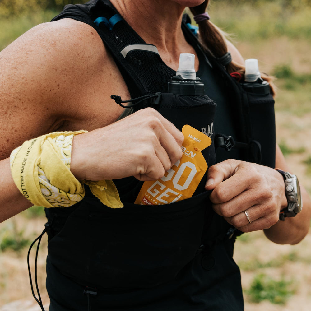 BARE Go Gel Endurance mango tube held in hand during exercise