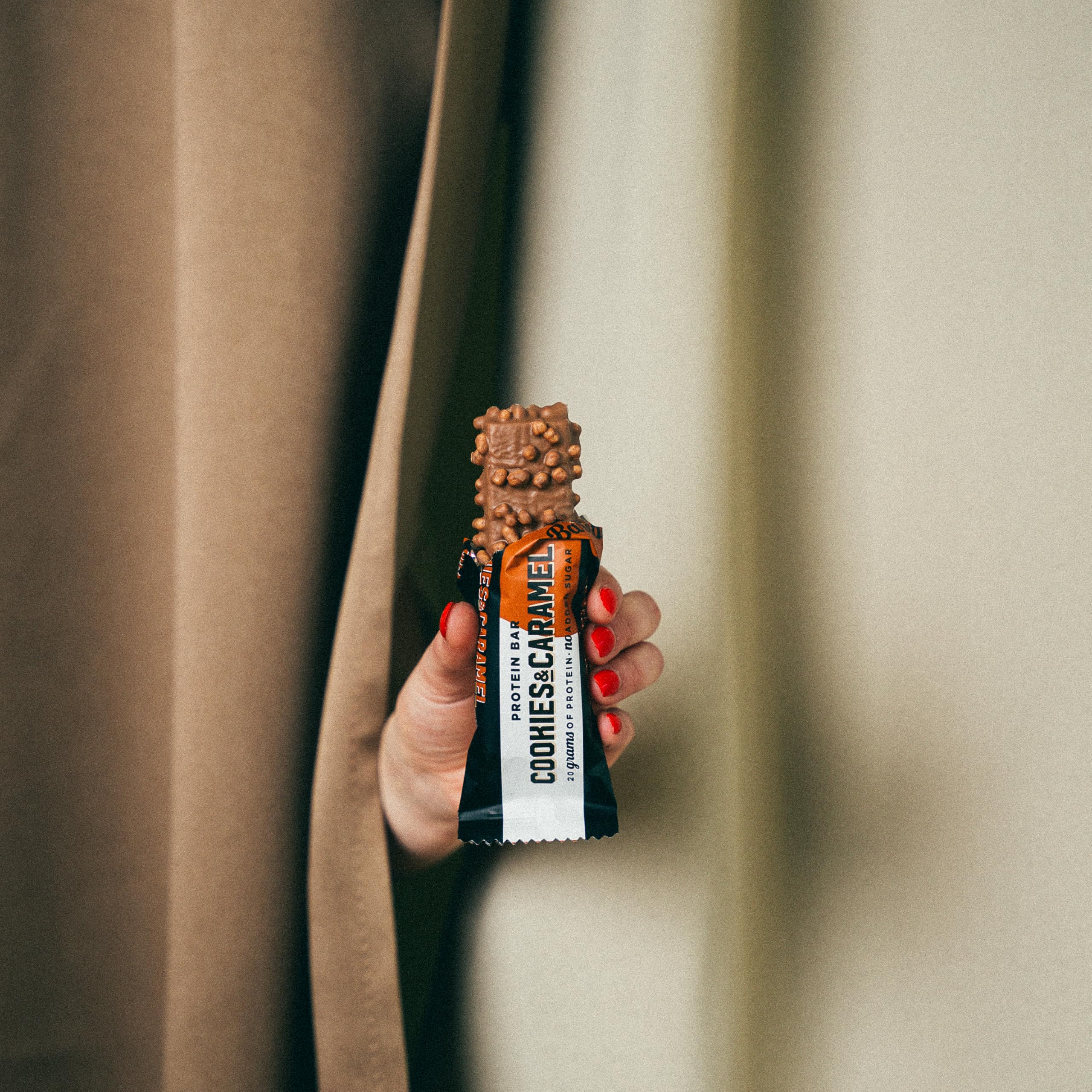 Barebells Cookies and Caramel bar pack-in-hand demonstrates portable protein for meals on the move