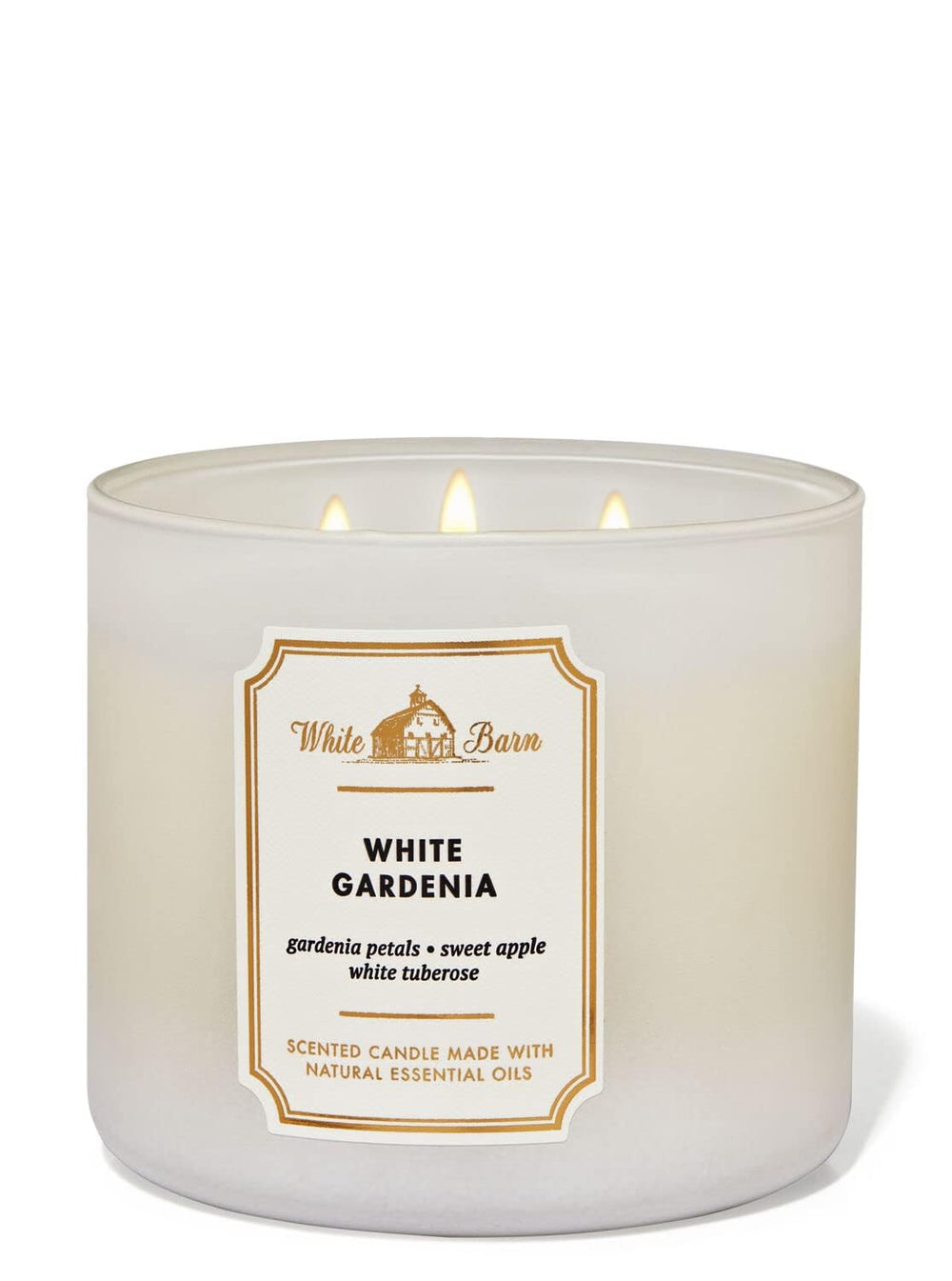 Lit Bath & Body Works White Barn candle emits warm glow with White Gardenia.