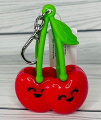 Bath & Body Works red-cherries PocketBac holder on bag demonstrates convenient travel sanitizing