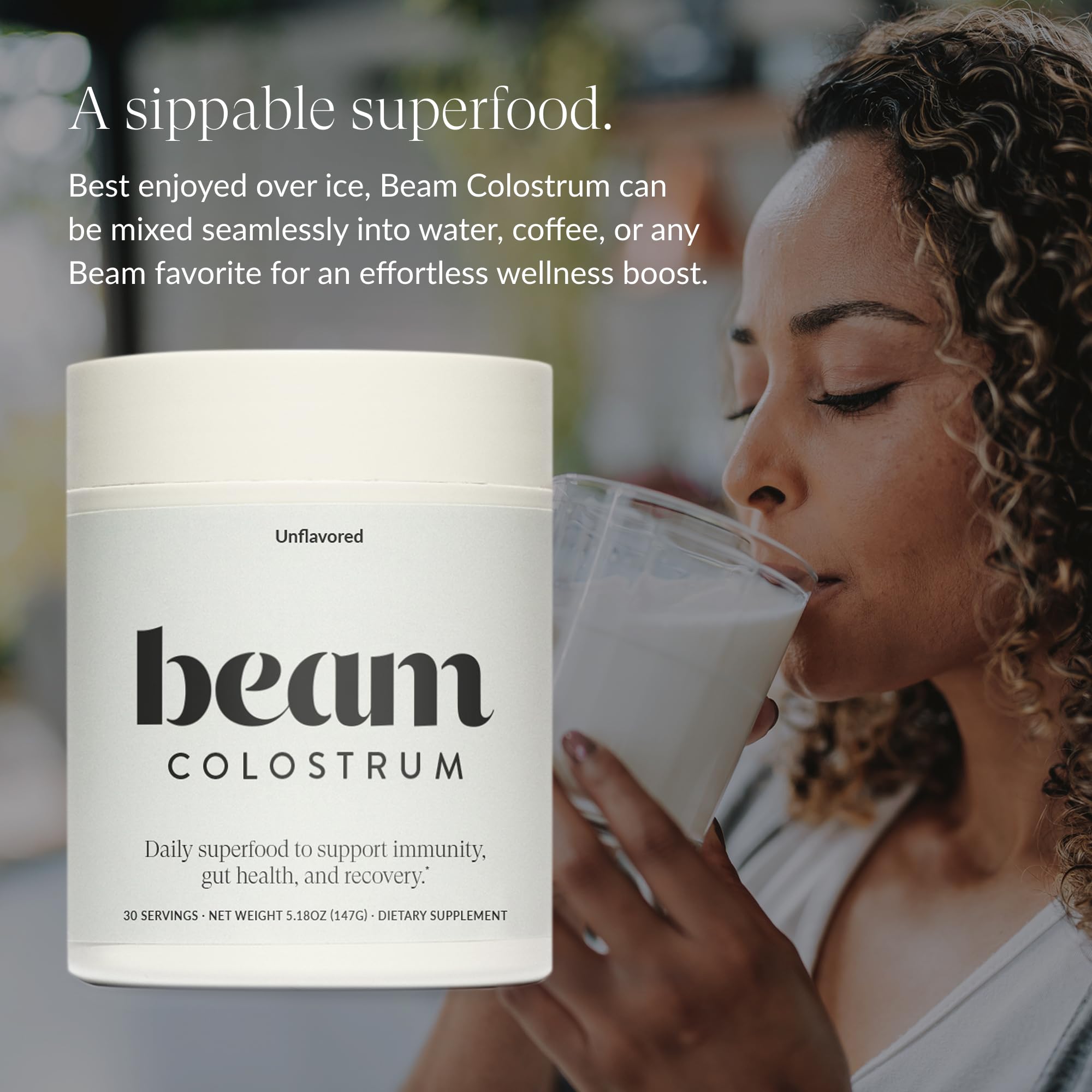 A scoop of Beam Colostrum Powder sits on a clean kitchen counter.