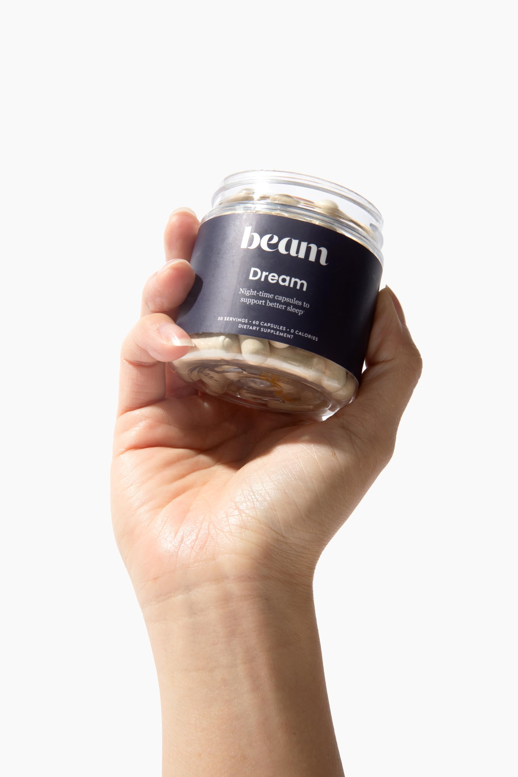 Open bottle with Beam Dream Sleep Capsules ready for a consistent nightly routine.