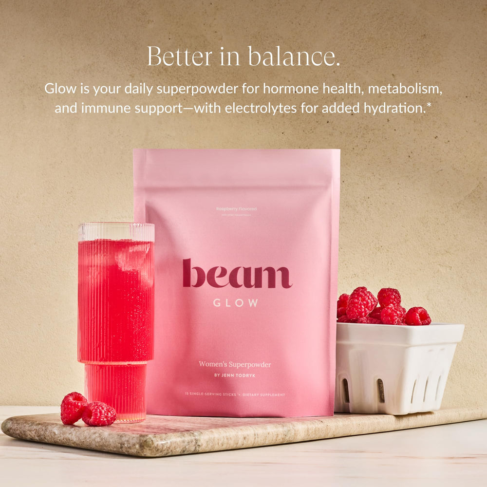 Beam Glow daily powder scoop beside water for easy mixing and consistent use.