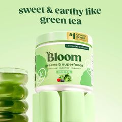 Bloom Nutrition greens powder scoop pouring into glass for easy mixing