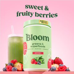 Bloom Nutrition greens powder scoop beside a glass of berry drink for easy mixing.