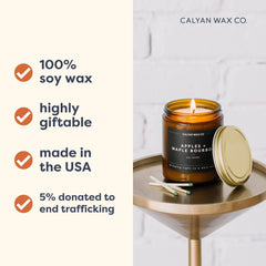 Calyan Wax Co. Apples and Maple Bourbon candle on a table with amber jar lit