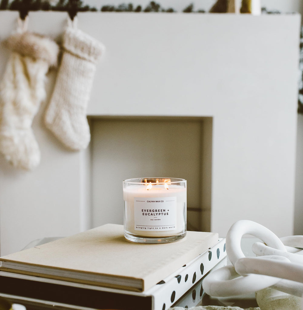 Calyan Wax Co Evergreen & Eucalyptus candle on plush decor for ambiance