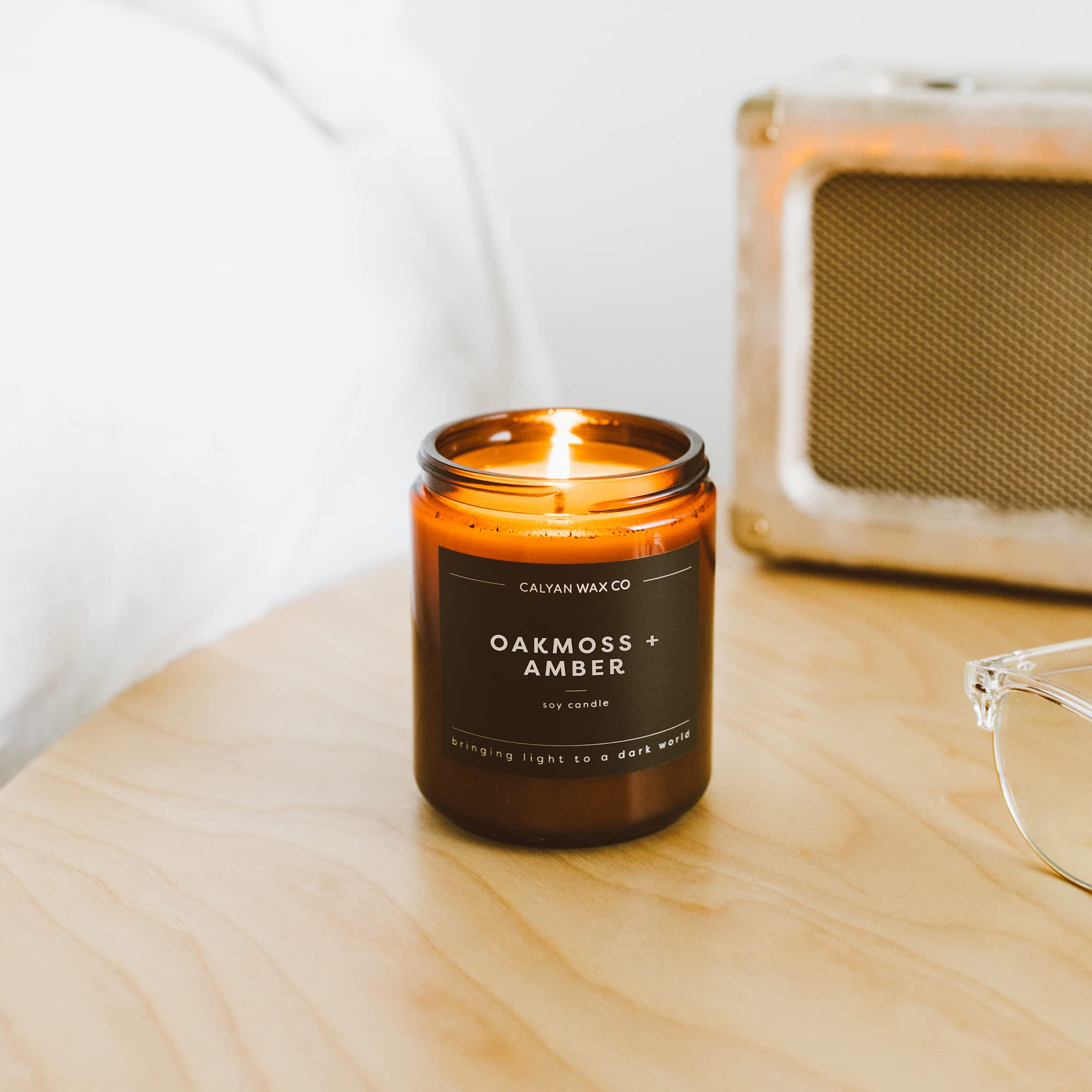 Calyan Wax Co. Oakmoss & Amber glows in a cozy living room.