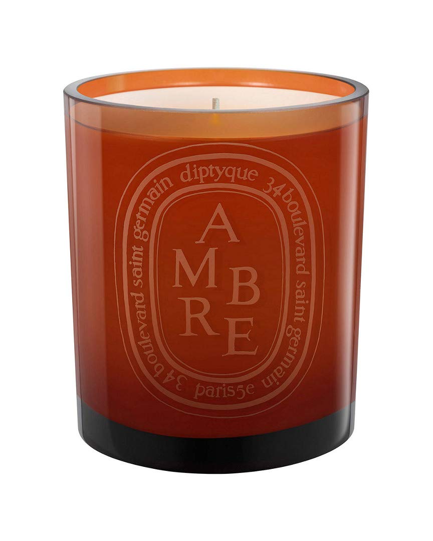 Diptyque Ambre scented candle glows warmly, creating a sophisticated ambience for relaxing evenings