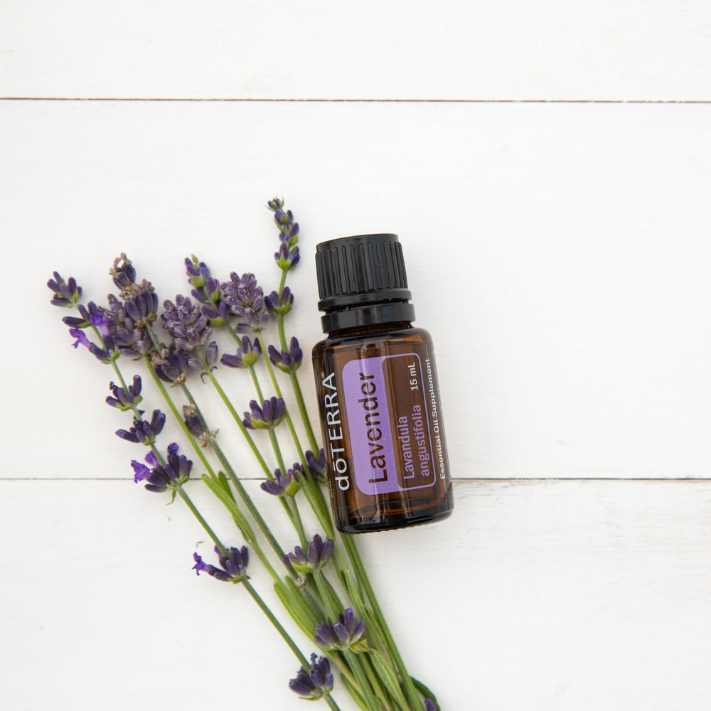 doTERRA lavender bottle beside candles for bedtime relaxation.