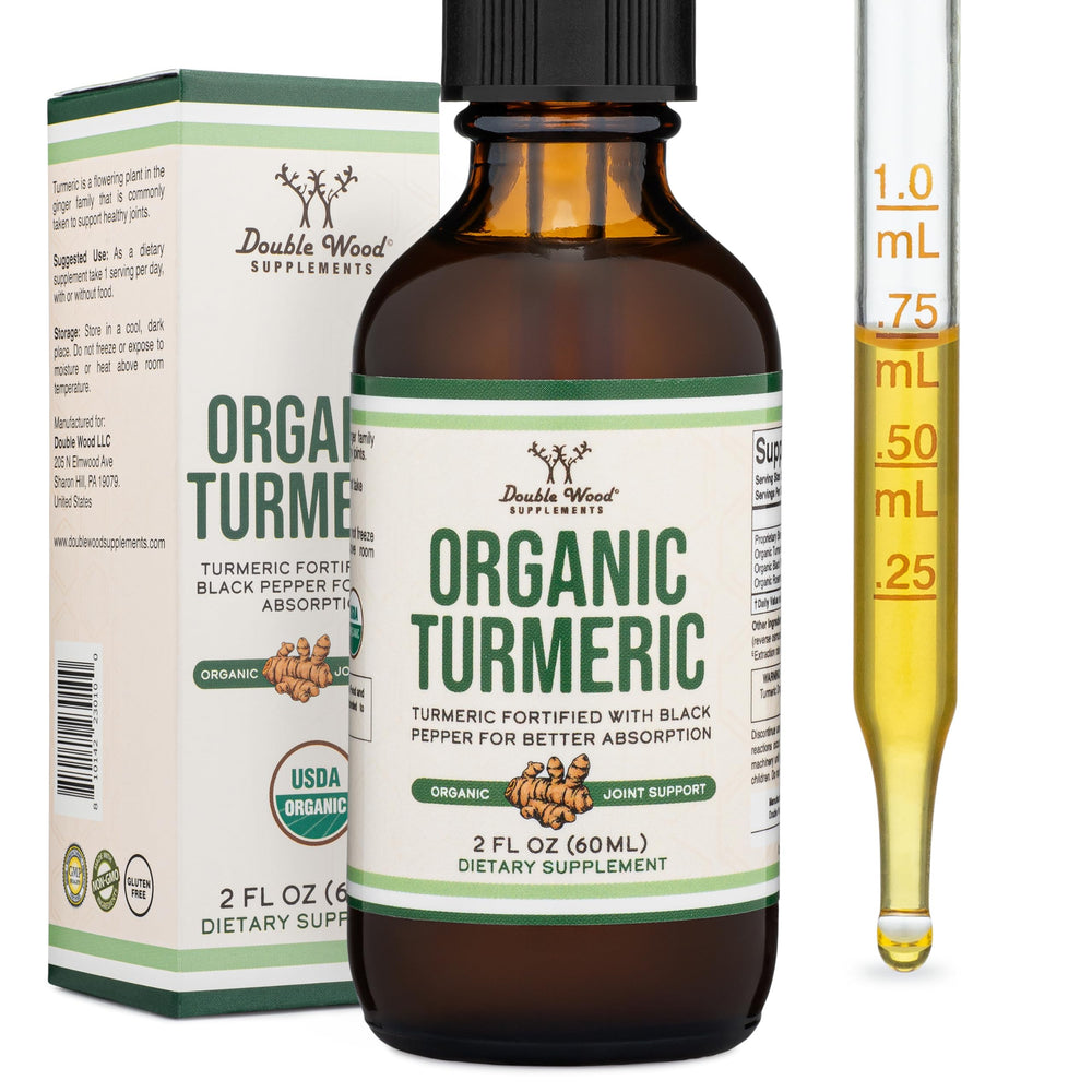 Double Wood Turmeric Drops bottle in hand for daily wellness.