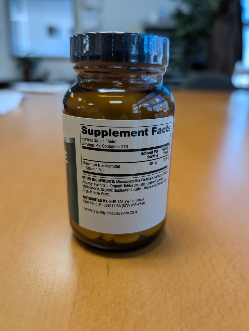 Glass bottle with Niacinamide tablets, clean and compact daily formulation.
