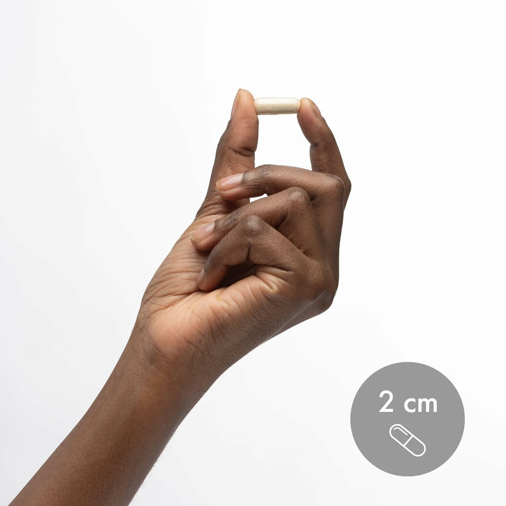 Person holding Dr. Mercola Zinc Plus Selenium bottle for daily routine.