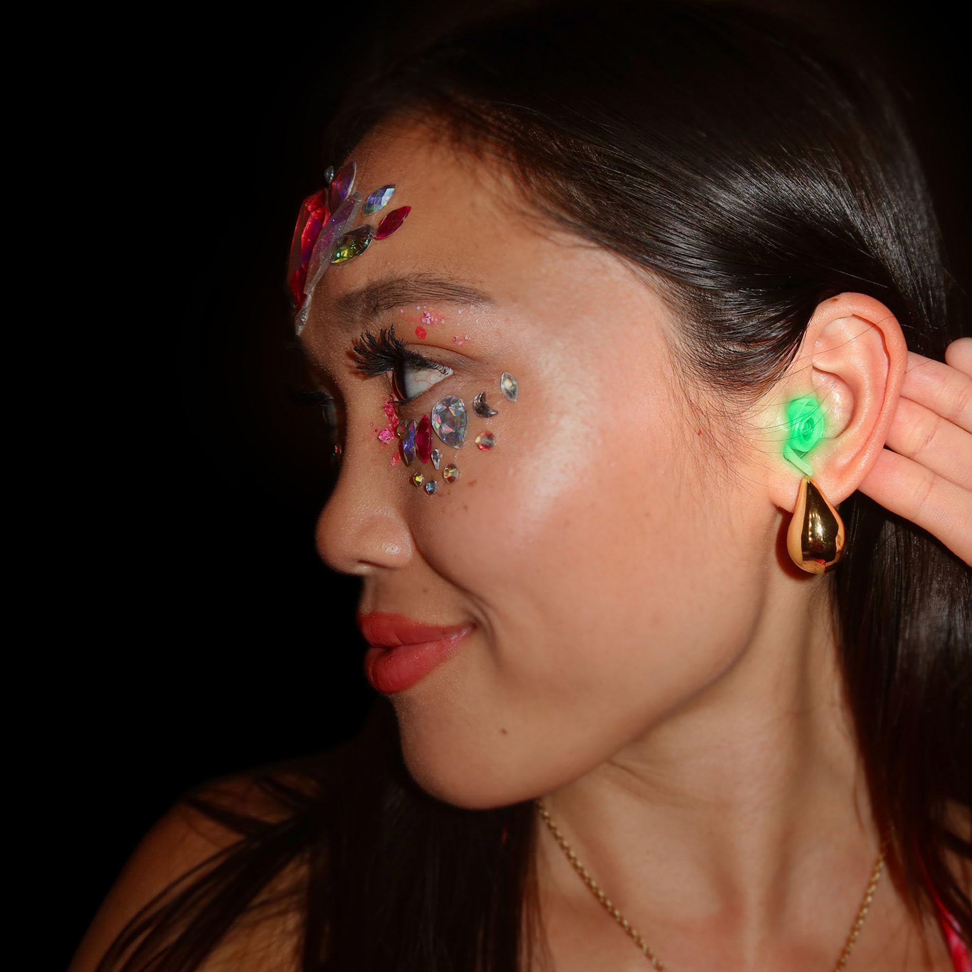 Festival scene with glow-ready earplugs protecting hearing while dancing.