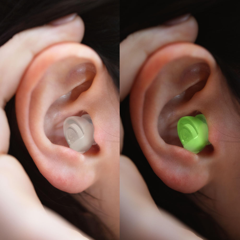 Glow-in-the-dark Eargasm earplugs in use at a dim venue