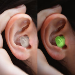 Glow-in-the-dark Eargasm earplugs in use at a dim venue