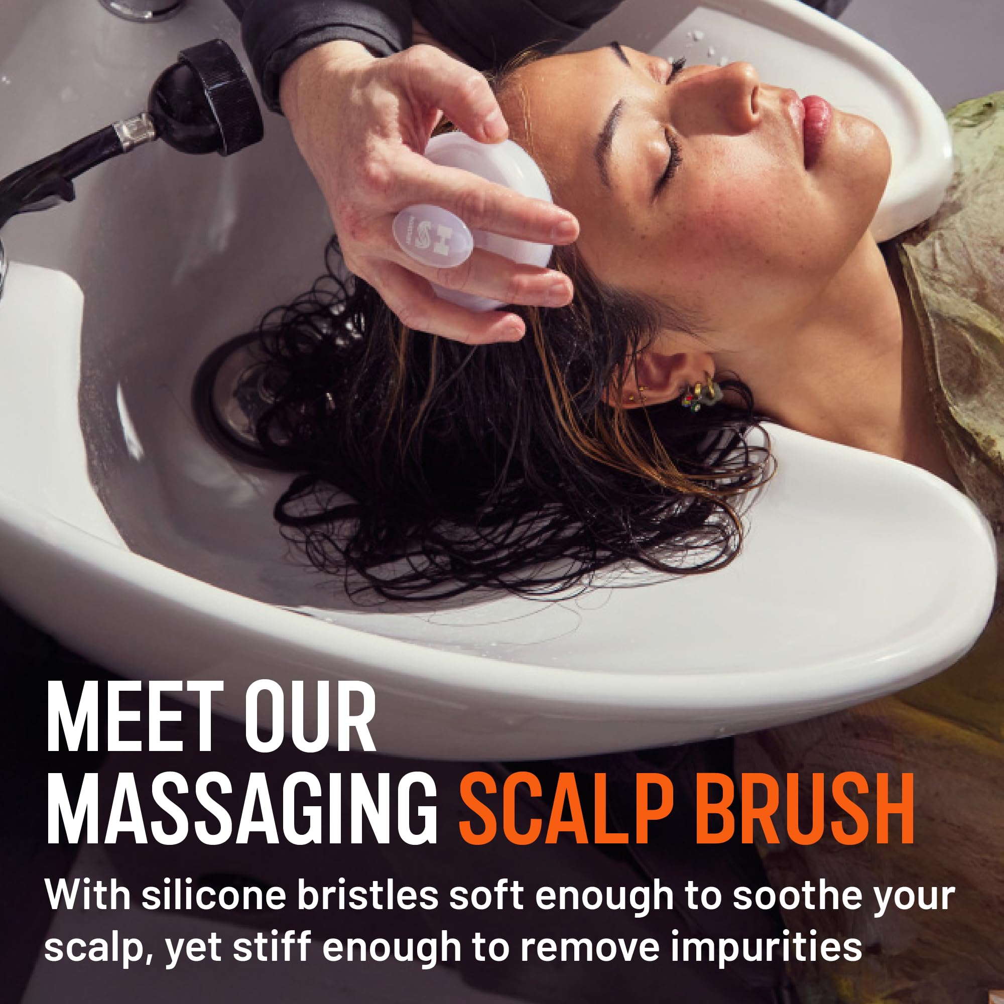 Hairstory Massaging Scalp Brush in hand for even product distribution.