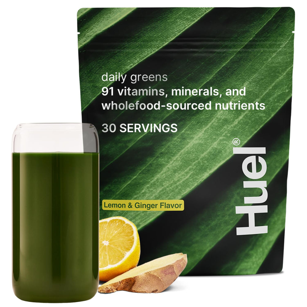 Huel Daily Greens powder scoop showing vibrant lemon-ginger blend for daily nutrient boost