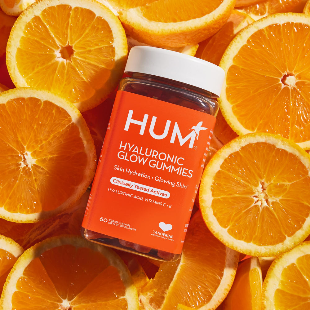 HUM Hyaluronic Glow bottle displayed on a shelf in a bathroom