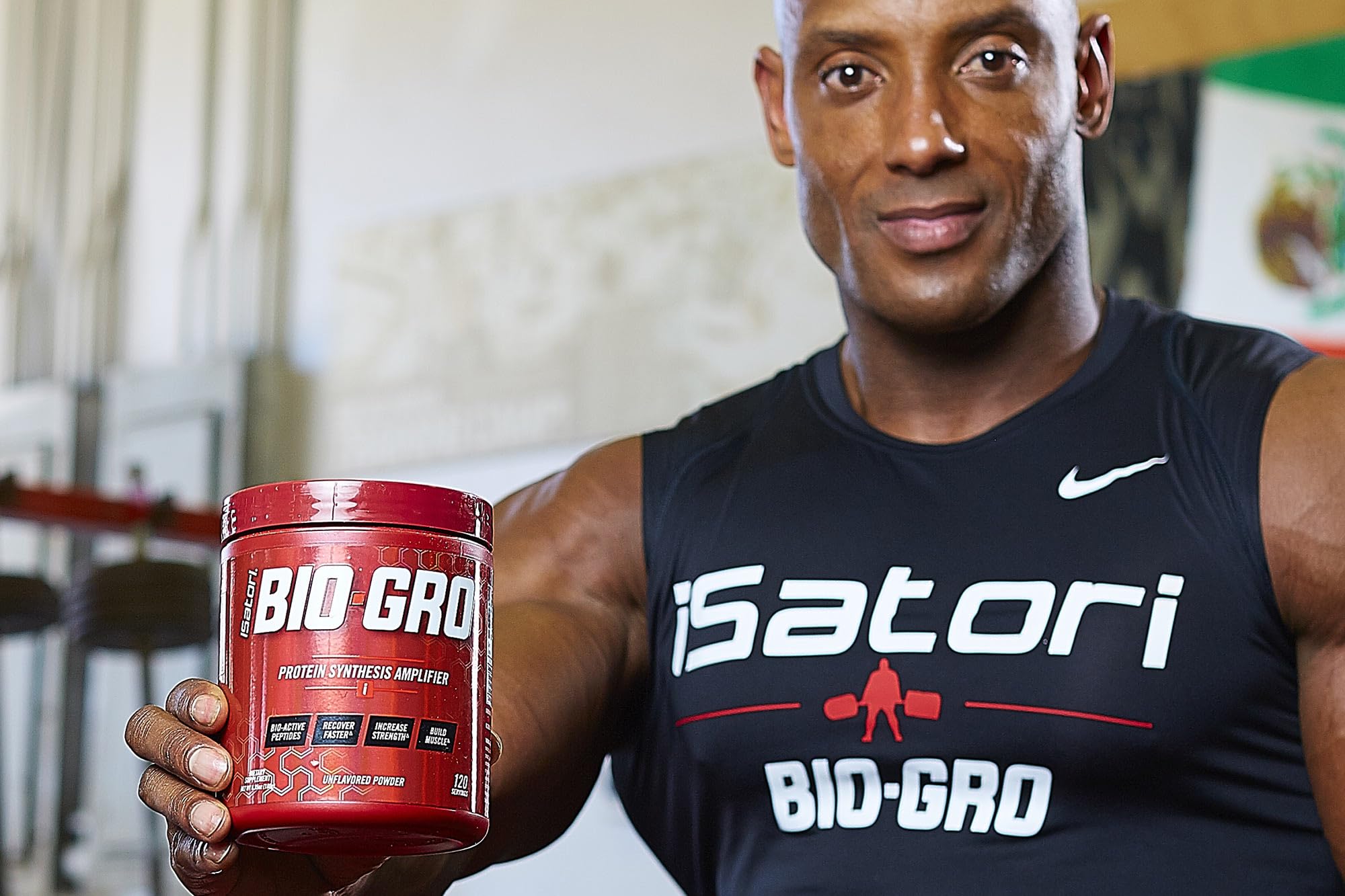 Isatori BIO-GRO 120 servings package against gym backdrop supports workouts.