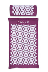 Kanjo acupressure mat in amethyst on bed, targeting back pressure points for relaxed muscles.