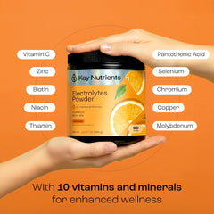 KEY NUTRIENTS mixed orange hydration drink in a glass after workout.