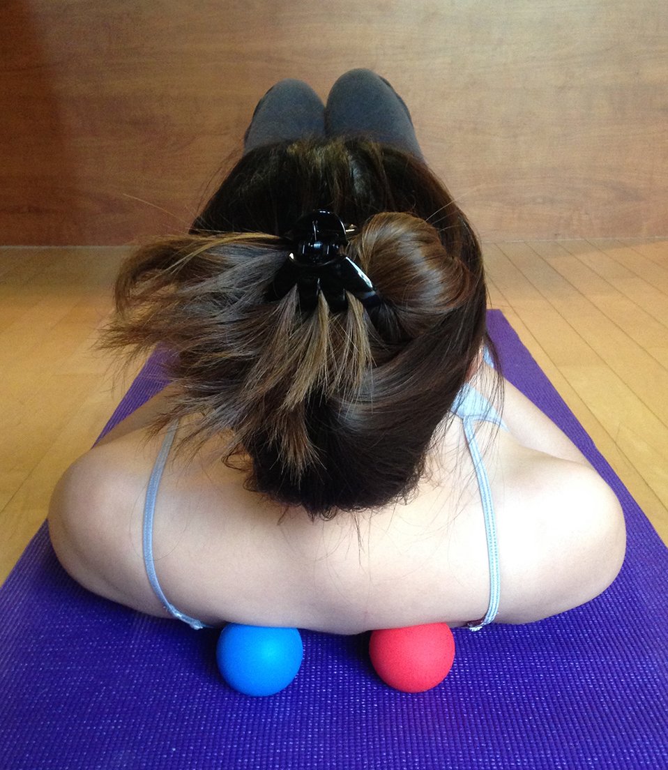 Kieba blue lacrosse ball on lower back to ease tightness