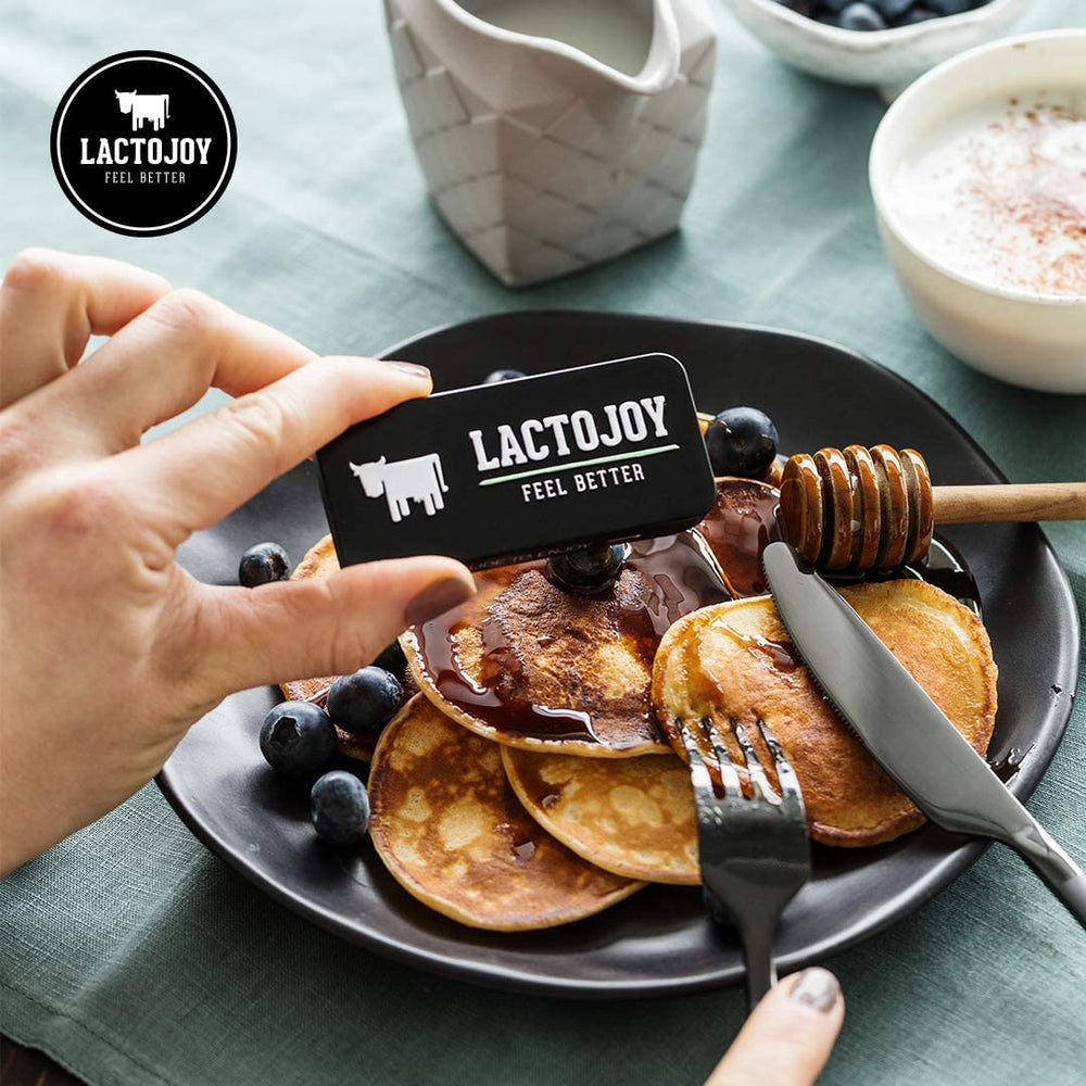 LactoJoy travel-friendly tin in hand for lactose-safe trips.