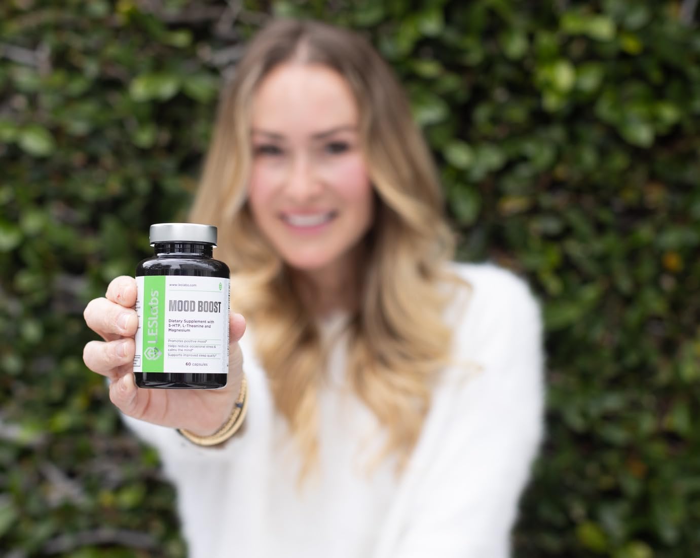 LES Labs Mood Boost capsules in hand suggest convenient on-the-go support.