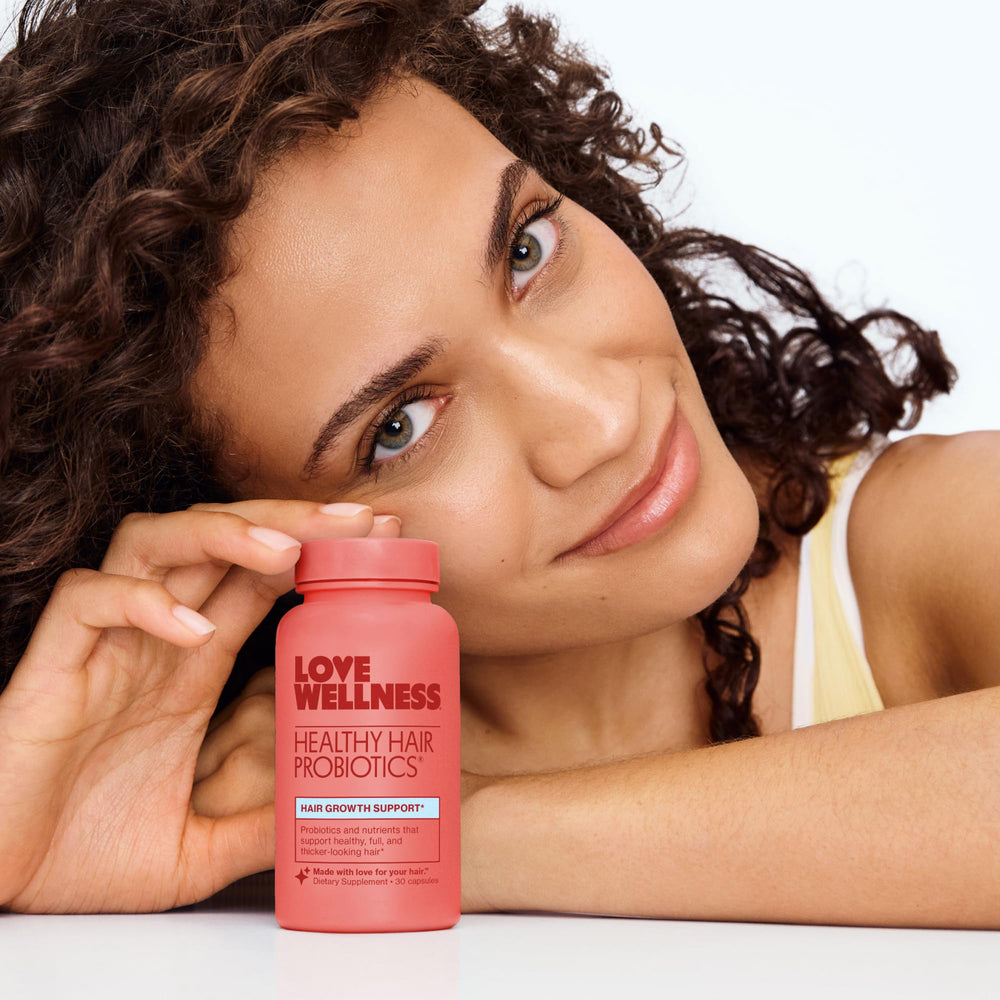 Love Wellness Healthy Hair Probiotics in hands illustrating easy daily supplementation.